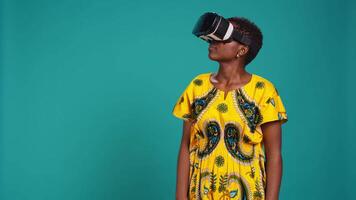 Young happy woman working with a virtual reality headset in studio, using the innovative 3d simulation experience with modern equipment. VR glasses on girl in traditional ethnic clothes. Camera B. video