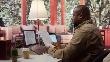 Businessman searching for commercial office spaces from his home workstation, doing a blueprints review and drafting building layouts to find the perfect startup property. Real estate. Camera B. video