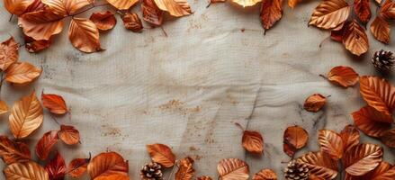 Dried Autumn Leaves Frame on Rustic Burlap Fabric Background photo