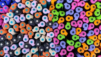 Abstract background of multicolored caps of plastic pens. A set of several liners, markers and colored markers of different colors, top view photo