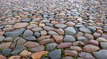 Wet multicolored cobblestone pavement in the city square on a rainy day photo