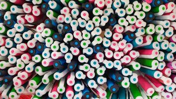 Abstract background of multicolored caps of plastic pens. A set of several liners, markers and colored markers of different colors, top view photo