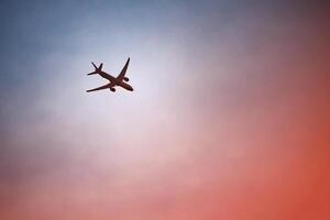 dark silhouette of an airplane in the dramatic evening sky photo