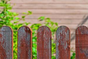 Fragment of a wooden fence painted red photo