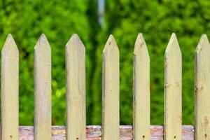 Fragment of a wooden fence a background of green garden photo