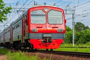 Train moves against the background of green trees photo