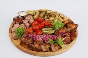 Food for a holiday for a large company. Hot meat snacks for beer served on wooden dish board on a white background photo