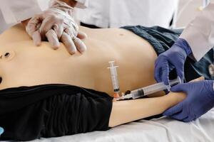 Medical Student Practicing Intravenous Injection on Training Dummy photo
