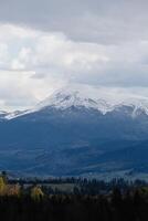 Snowy mountain range under cloudy sky photo