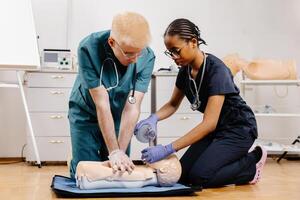 Two medical professionals practice CPR on a training mannequin, demonstrating proper technique and teamwork photo