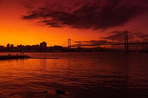 Hercilio luz cable bridge with sunset sky and reflection on water in Florianopolis photo