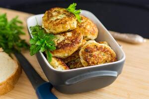 fried meat cutlets in a ceramic form on a wooden table photo