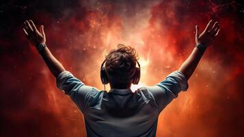 A man with his hands raised in the air, with a red and orange background photo