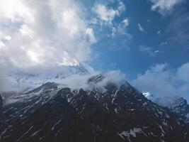 clouds over the mountains, mountains in the fog, during annapurna, annapurna base camp nepal photo