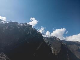 clouds over the mountains, mountains in the fog, during annapurna, annapurna base camp nepal photo