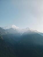 clouds over the mountains, mountains in the fog, during annapurna base camp, ghandruk, nepal photo