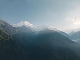 clouds over the mountains, mountains in the fog, during annapurna base camp, ghandruk, nepal photo