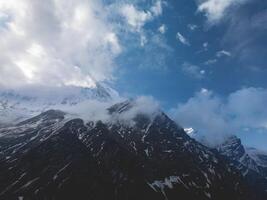 clouds over the mountains, mountains in the fog, during annapurna, annapurna base camp nepal photo