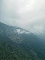clouds over the mountains, mountains in the fog, during annapurna base camp, ghandruk, nepal photo