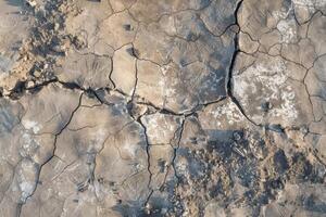 Top view photo of a solid color ground showing a large collapsed area from a strong impact, with cracks radiating outward