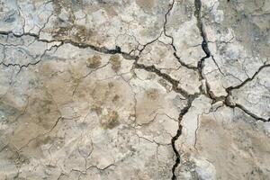 Top view photo of a solid color ground showing a large collapsed area from a strong impact, with cracks radiating outward
