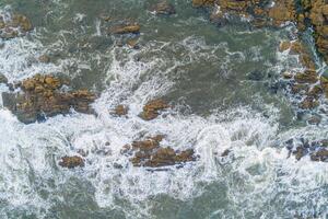directly above drone view of a rocky beach shore, aerial shot with drone photo
