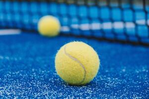 selective focus, two paddle tennis balls near the the net of a paddle tennis court photo