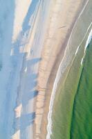 shore of a beach at sunrise in summer as seen from a drone, directly above image photo