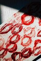 Imprint of red lips on white paper, kiss background photo