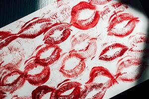 Imprint of red lips on white paper, kiss background photo