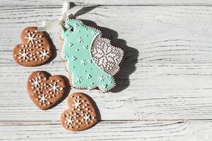 Homemade cookies in the shape of hearts and gingerbread in the shape of a Christmas tree with snowflakes photo