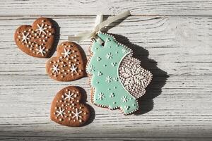 Homemade cookies in the shape of hearts and gingerbread in the shape of a Christmas tree with snowflakes photo