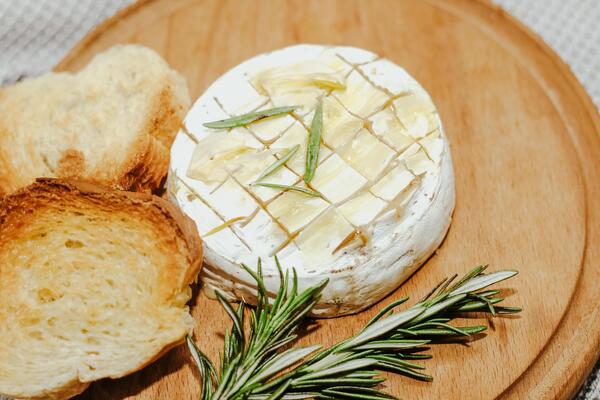 White baguette cut into pieces with olive oil and Camembert cheese on the table.