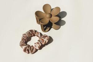 Hair clip and silk elastic on a beige background photo