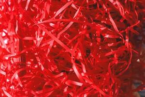 Decorative red confetti of red color cut into a strip, eco for gift wrapping photo