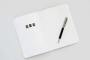 Filling in the diary, the inscription May in the notebook in a dot photo