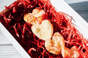 Homemade cookies in the shape of hearts are packed in a festive box photo
