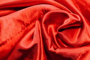 Red shiny texture of silk satin satin with folds. photo