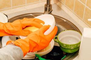A pile of dirty dishes, cups, plates in the sink, washing with an eraser. photo