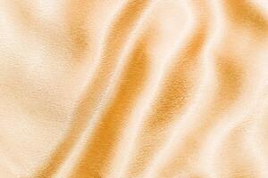 Yellow shiny texture of silk satin satin with folds. photo