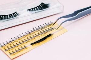 Artificial false fluffy eyelashes with tweezers. photo