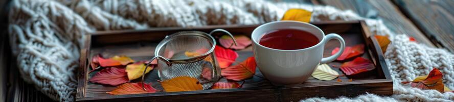 Cozy Tea Time, Mug with Sieve and Colorful Leaves on Rustic Tray photo