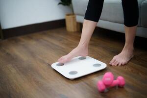 Fat diet and scale feet standing on electronic scales for weight control. Measurement instrument in kilogram for a diet control photo