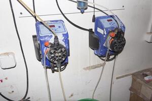 A room for dosing chemicals of chlorine and acid when feeding into the pool. Water circulation system in the pumping room. photo