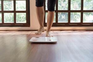 Fat diet and scale feet standing on electronic scales for weight control. Measurement instrument in kilogram for a diet control photo