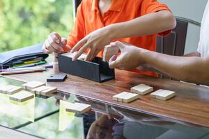 Asian father and son playing wood blocks game Carefree kid playing wood blocks game building constructor from blocks with father at home photo