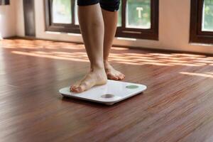 Fat diet and scale feet standing on electronic scales for weight control. Measurement instrument in kilogram for a diet control photo