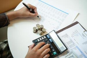 Businessman Saving money analyzing investment charts and pressing calculator buttons over documents. Accounting Concept photo