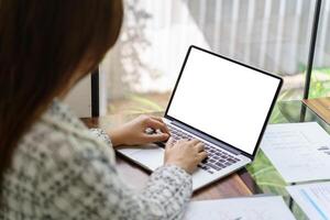 Woman Working by using laptop blank screen computer . Hands typing on a keyboard.technology e-commerce concept photo