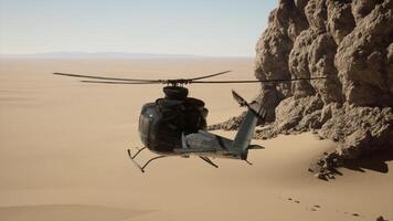 A helicopter flying over a desert with a rock formation in the background photo